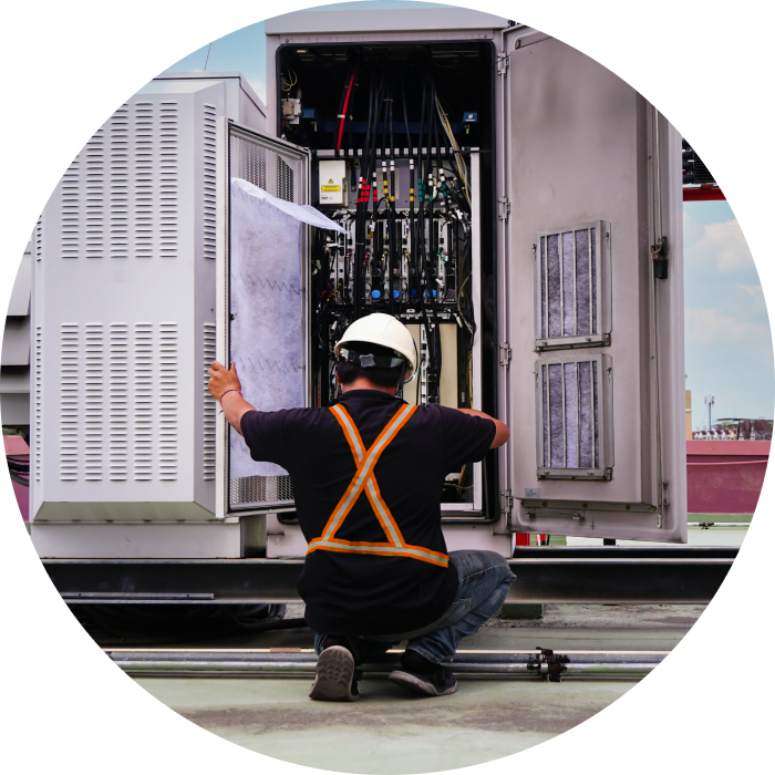 A telecommunications technician working on equipment